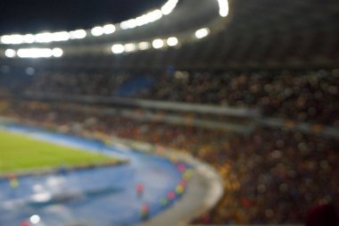 Alacakaranlık vakti, soyut arka plan kullanımı için futbol stadyumunun bulanık görüntüsü.