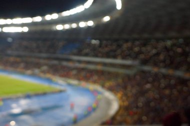 Alacakaranlık vakti, soyut arka plan kullanımı için futbol stadyumunun bulanık görüntüsü.