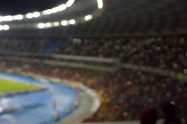 Alacakaranlık vakti, soyut arka plan kullanımı için futbol stadyumunun bulanık görüntüsü.