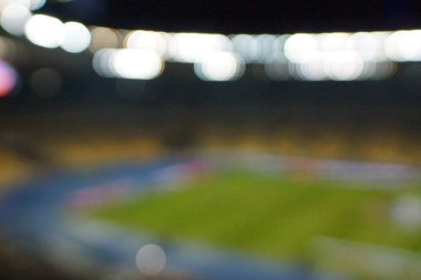 Alacakaranlık vakti, soyut arka plan kullanımı için futbol stadyumunun bulanık görüntüsü.