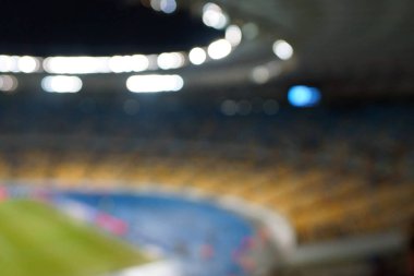 Alacakaranlık vakti, soyut arka plan kullanımı için futbol stadyumunun bulanık görüntüsü.