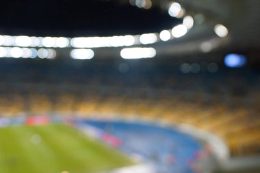 Alacakaranlık vakti, soyut arka plan kullanımı için futbol stadyumunun bulanık görüntüsü.