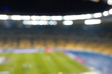 Alacakaranlık vakti, soyut arka plan kullanımı için futbol stadyumunun bulanık görüntüsü.