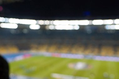 Alacakaranlık vakti, soyut arka plan kullanımı için futbol stadyumunun bulanık görüntüsü.