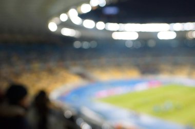 Alacakaranlık vakti, soyut arka plan kullanımı için futbol stadyumunun bulanık görüntüsü.