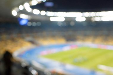 Alacakaranlık vakti, soyut arka plan kullanımı için futbol stadyumunun bulanık görüntüsü.