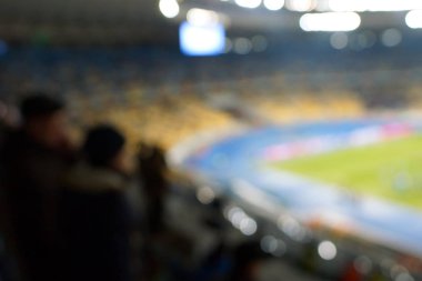 Alacakaranlık vakti, soyut arka plan kullanımı için futbol stadyumunun bulanık görüntüsü.
