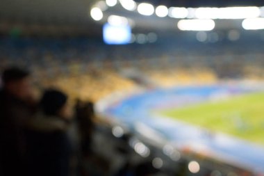 Alacakaranlık vakti, soyut arka plan kullanımı için futbol stadyumunun bulanık görüntüsü.