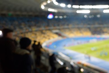 Alacakaranlık vakti, soyut arka plan kullanımı için futbol stadyumunun bulanık görüntüsü.