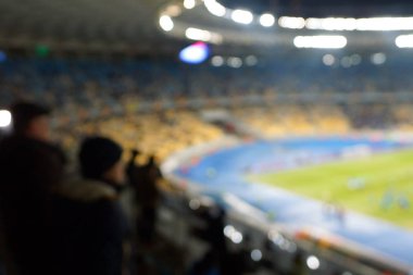 Alacakaranlık vakti, soyut arka plan kullanımı için futbol stadyumunun bulanık görüntüsü.