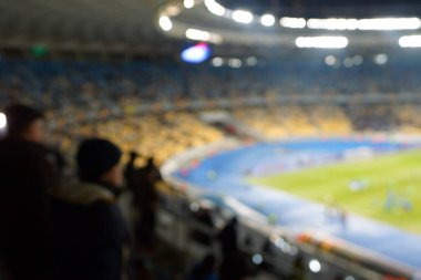 Alacakaranlık vakti, soyut arka plan kullanımı için futbol stadyumunun bulanık görüntüsü.