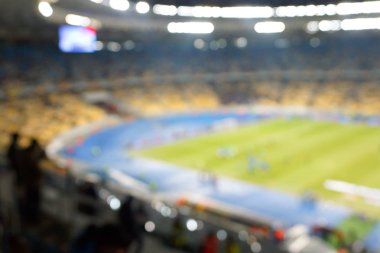 Alacakaranlık vakti, soyut arka plan kullanımı için futbol stadyumunun bulanık görüntüsü.