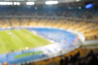 Alacakaranlık vakti, soyut arka plan kullanımı için futbol stadyumunun bulanık görüntüsü.