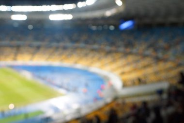 Alacakaranlık vakti, soyut arka plan kullanımı için futbol stadyumunun bulanık görüntüsü.