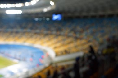 Alacakaranlık vakti, soyut arka plan kullanımı için futbol stadyumunun bulanık görüntüsü.