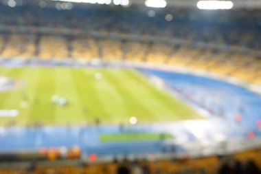 Alacakaranlık vakti, soyut arka plan kullanımı için futbol stadyumunun bulanık görüntüsü.