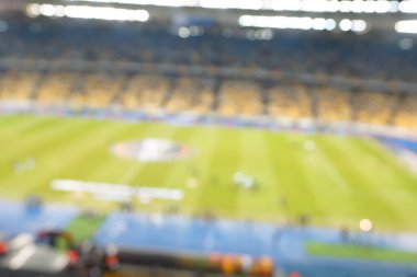 Alacakaranlık vakti, soyut arka plan kullanımı için futbol stadyumunun bulanık görüntüsü.