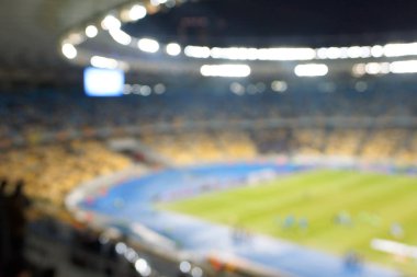 Alacakaranlık vakti, soyut arka plan kullanımı için futbol stadyumunun bulanık görüntüsü.