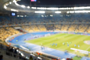 Alacakaranlık vakti, soyut arka plan kullanımı için futbol stadyumunun bulanık görüntüsü.