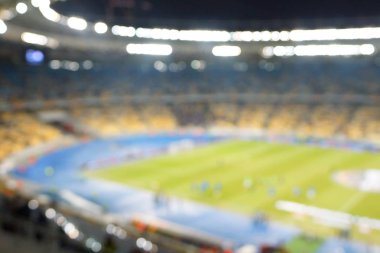 Alacakaranlık vakti, soyut arka plan kullanımı için futbol stadyumunun bulanık görüntüsü.
