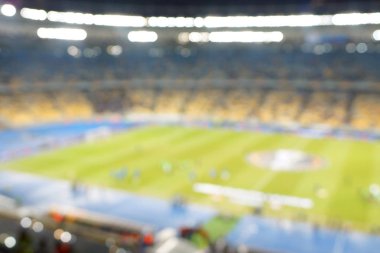 Alacakaranlık vakti, soyut arka plan kullanımı için futbol stadyumunun bulanık görüntüsü.