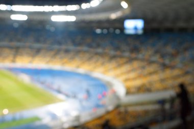 Alacakaranlık vakti, soyut arka plan kullanımı için futbol stadyumunun bulanık görüntüsü.