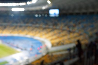Alacakaranlık vakti, soyut arka plan kullanımı için futbol stadyumunun bulanık görüntüsü.