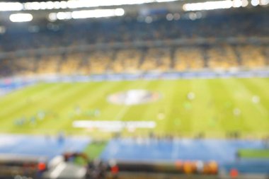 Alacakaranlık vakti, soyut arka plan kullanımı için futbol stadyumunun bulanık görüntüsü.
