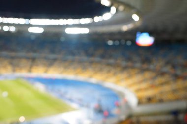 Alacakaranlık vakti, soyut arka plan kullanımı için futbol stadyumunun bulanık görüntüsü.