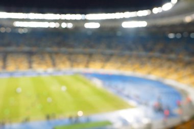 Alacakaranlık vakti, soyut arka plan kullanımı için futbol stadyumunun bulanık görüntüsü.
