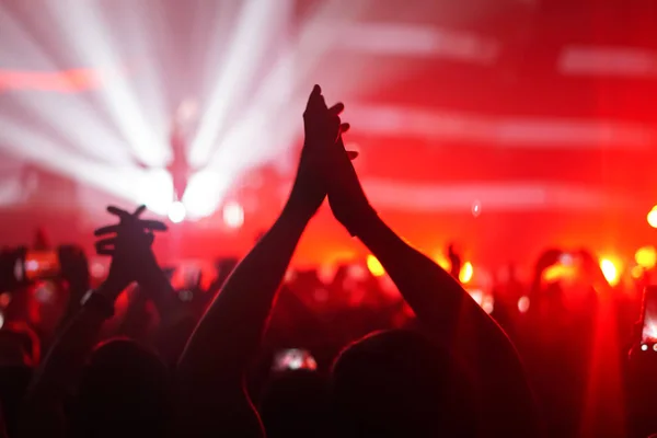 Silhuetas de multidão de concerto na frente de luzes de palco brilhantes — Fotografia de Stock