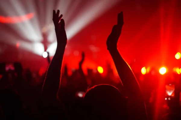 Siluetas de la multitud de conciertos frente a luces de escenario brillantes —  Fotos de Stock