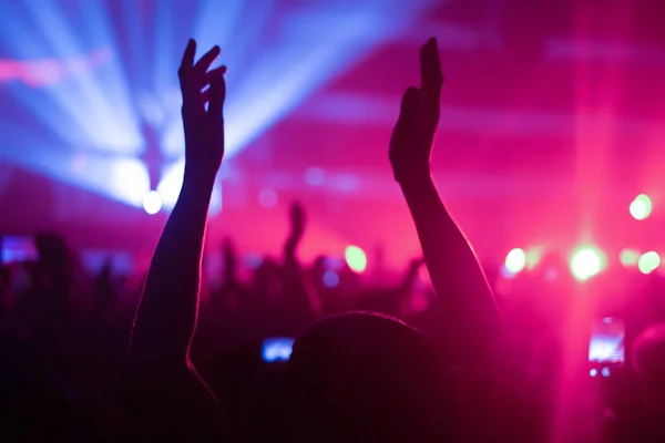 Siluetas de la multitud de conciertos frente a luces de escenario brillantes —  Fotos de Stock