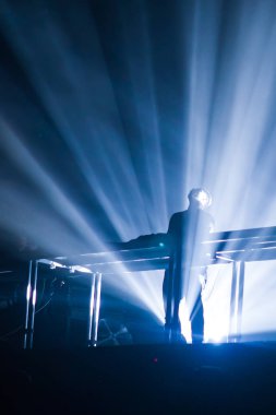 Konserin siluetleri parlak sahne ışıkları önünde kalabalık. Gece hayatı ve konser parti konsept.