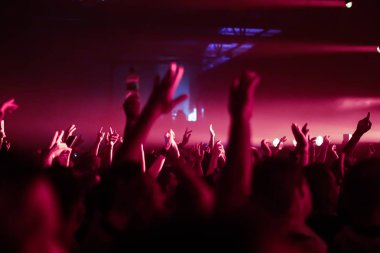 Konserin siluetleri parlak sahne ışıkları önünde kalabalık. Gece hayatı ve konser parti konsept.