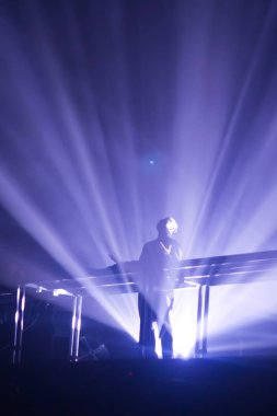 Konserin siluetleri parlak sahne ışıkları önünde kalabalık. Gece hayatı ve konser parti konsept.