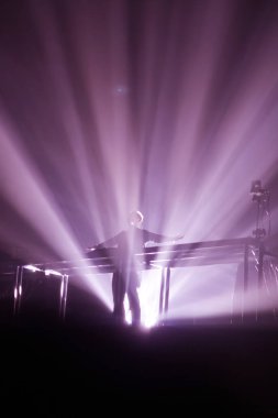 Konserin siluetleri parlak sahne ışıkları önünde kalabalık. Gece hayatı ve konser parti konsept.