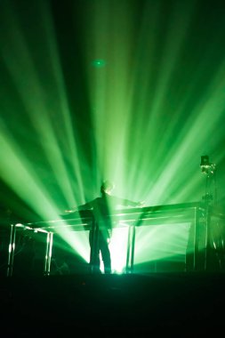 Konserin siluetleri parlak sahne ışıkları önünde kalabalık. Gece hayatı ve konser parti konsept.