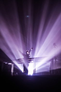 Konserin siluetleri parlak sahne ışıkları önünde kalabalık. Gece hayatı ve konser parti konsept.