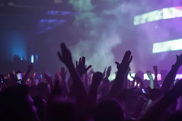 Silhouetten von Konzertbesuchern vor hellen Bühnenlichtern. Nachtleben und Konzert-Party-Konzept. — Stockfoto