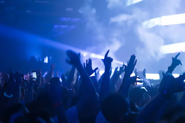 Silhuetas de multidão de concertos em frente a luzes de palco brilhantes. Conceito de vida noturna e festa de concerto . — Fotografia de Stock