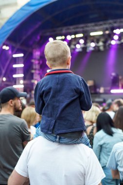 Çocuklar bir sokak konserinde boynuna dolanıyor