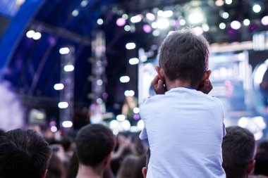 Çocuklar bir sokak konserinde boynuna dolanıyor