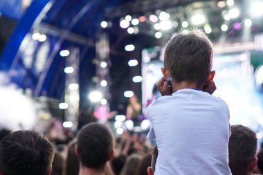 Çocuklar bir sokak konserinde boynuna dolanıyor