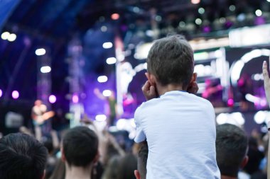 Çocuklar bir sokak konserinde boynuna dolanıyor