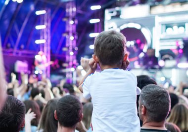 Çocuklar bir sokak konserinde boynuna dolanıyor