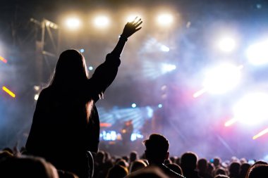 Müzik festivalinde kalabalığın içinde omuzlarında bir kız.