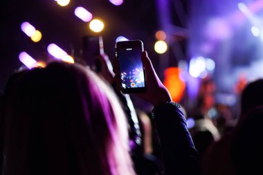 Bir konser sırasında akıllı telefonla fotoğraf çekmeyi kapat
