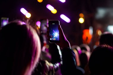 Bir konser sırasında akıllı telefonla fotoğraf çekmeyi kapat