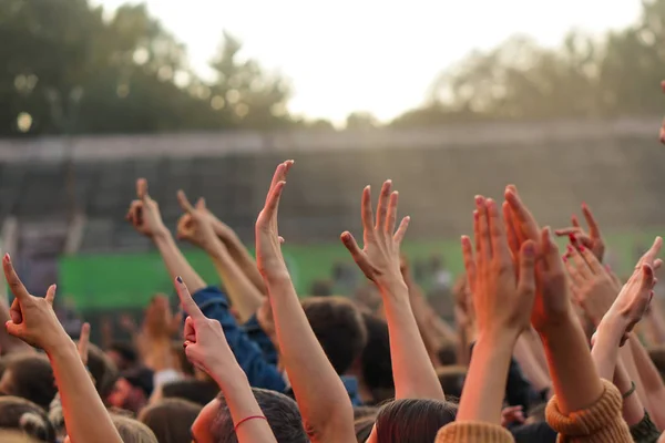 Bir müzik festivalinde seyirciler ellerini kaldırdı ve sahnenin üstünden ışıklar süzülüyor.. — Stok fotoğraf